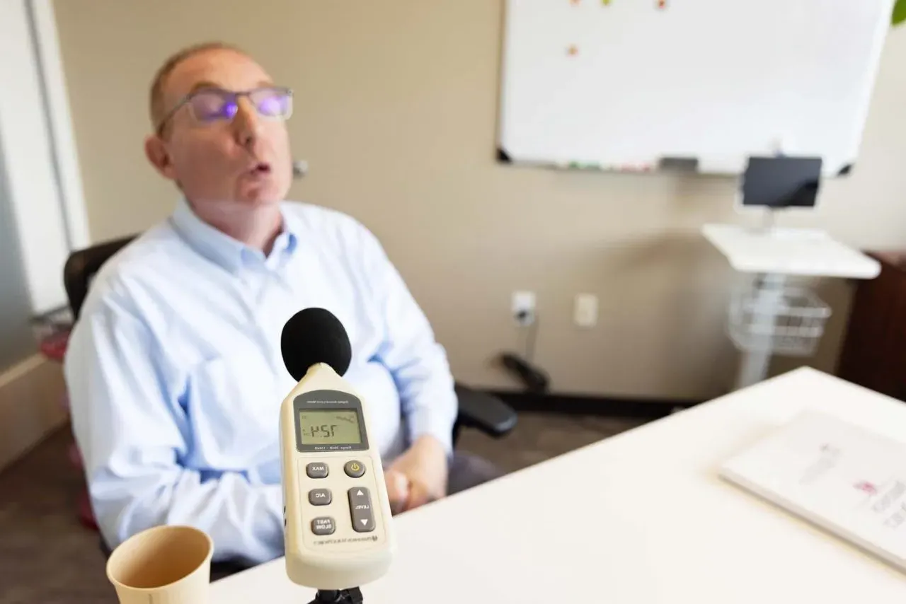 Client that has Parkinson's Disease. There is a microphone in front of the client.