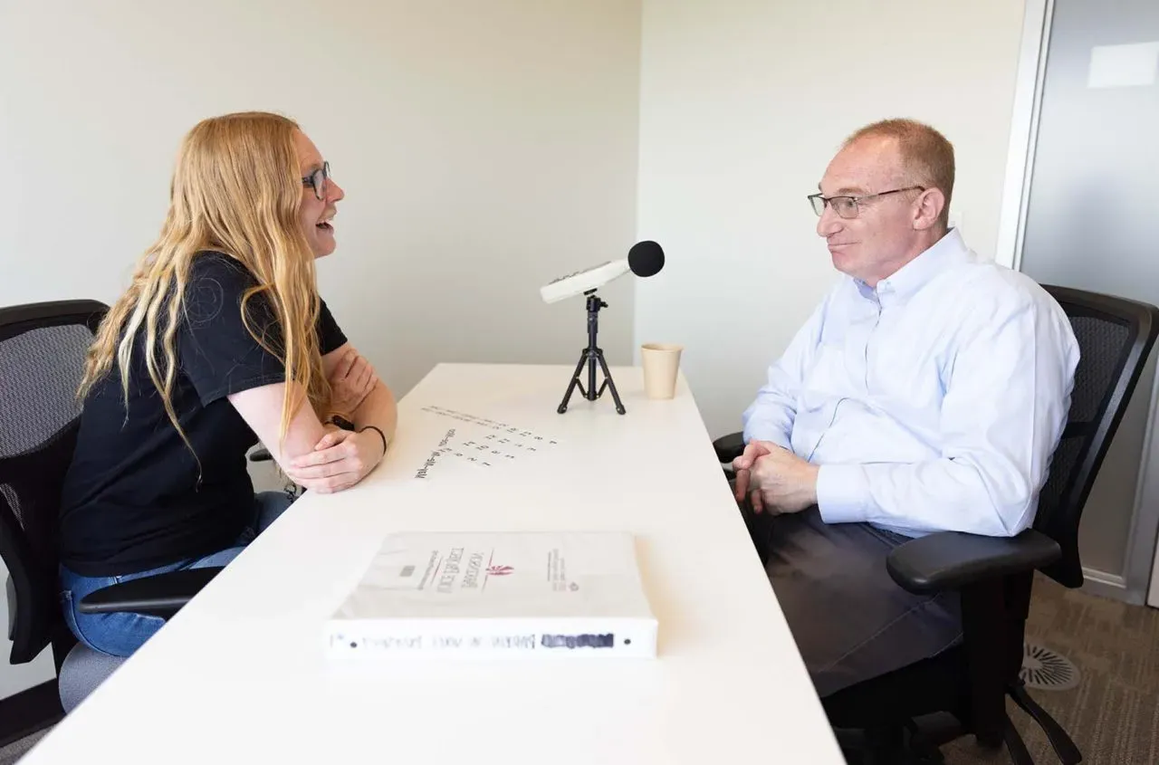 Graduate Clinician working with a client that has Parkinson's Disease. There is a microphone in front of the client.